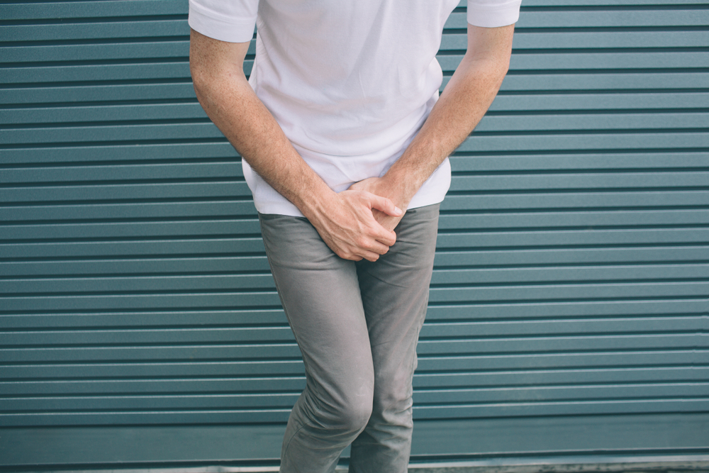 Man covering crotch area with hands