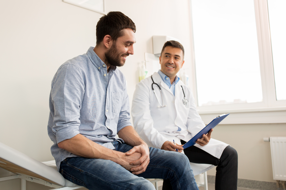 smiling man talking with doctor.